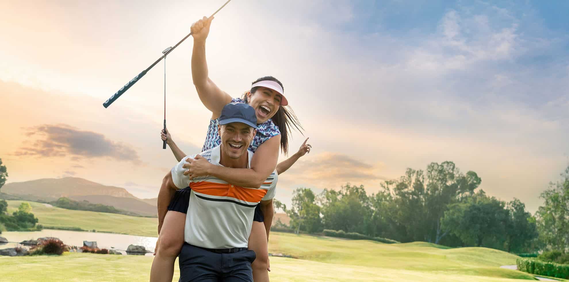 Smiling man and girl playing golf outdoors at sunset.