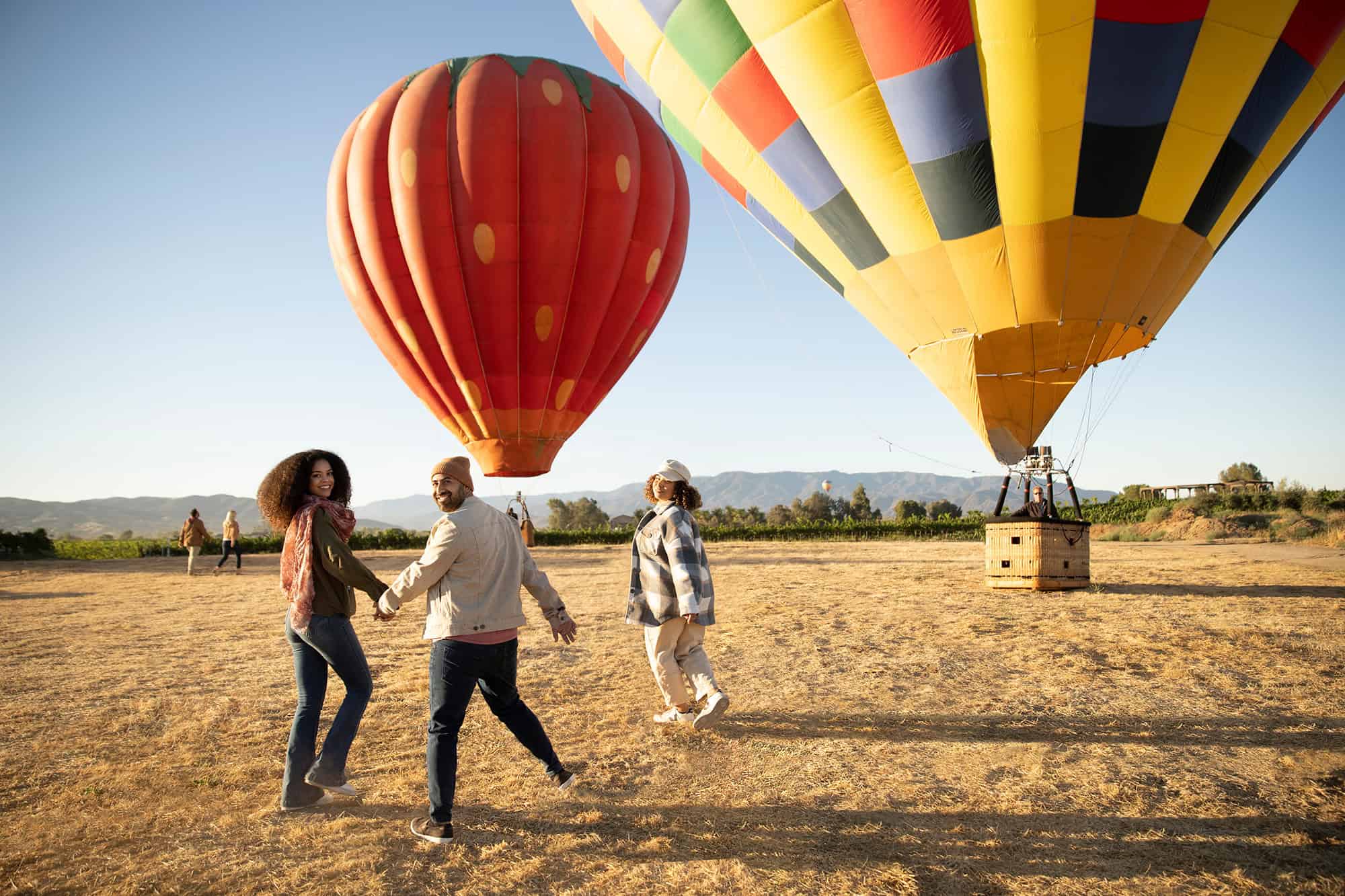 Colorful hot air balloons with people enjoying a festival in the USA.