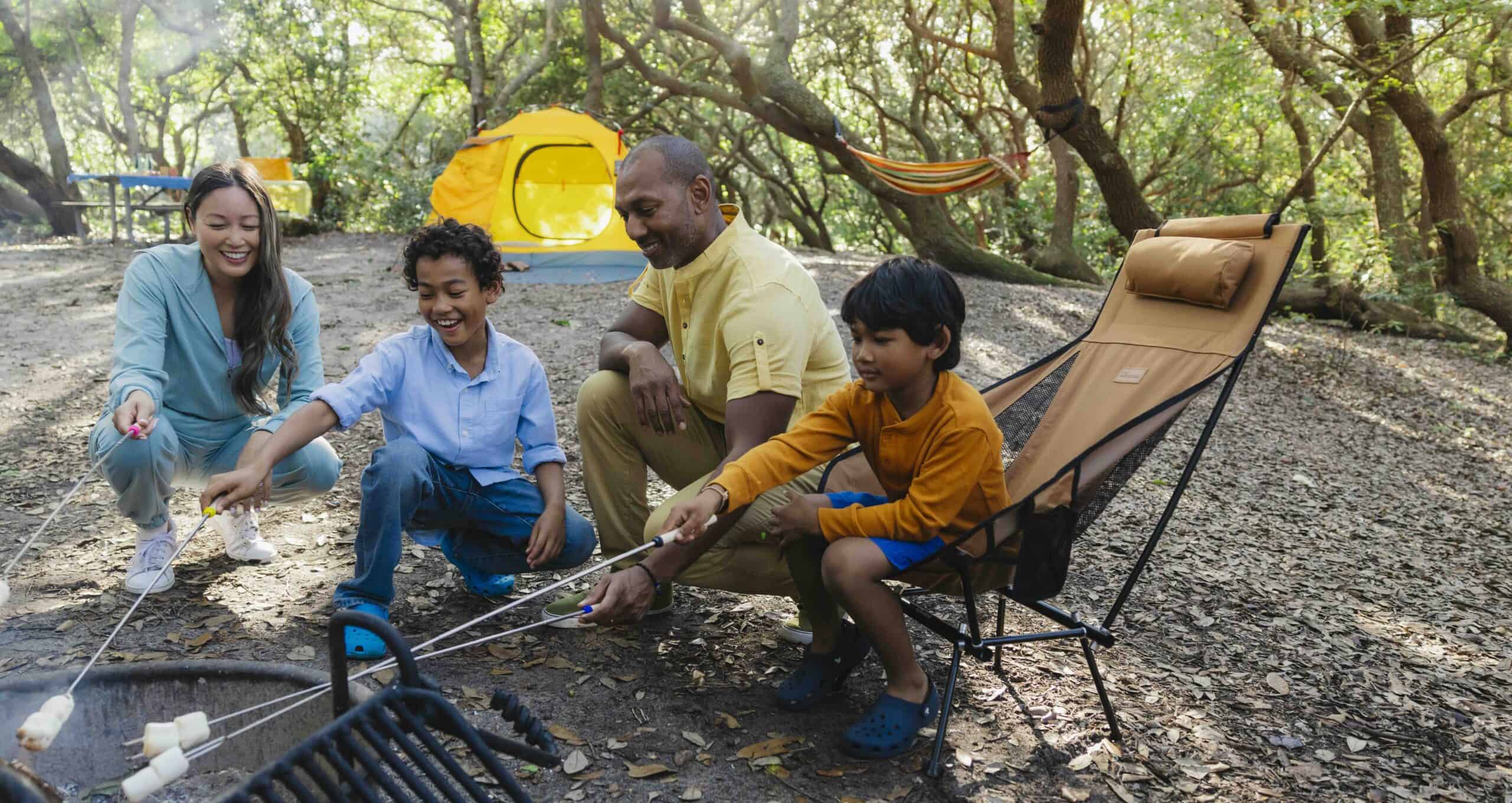 Family enjoying camping and fishing in a wooded outdoor setting.