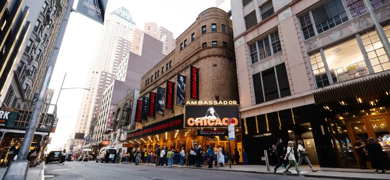 Night view of Chicago Theater District with illuminated signs and busy street scene.