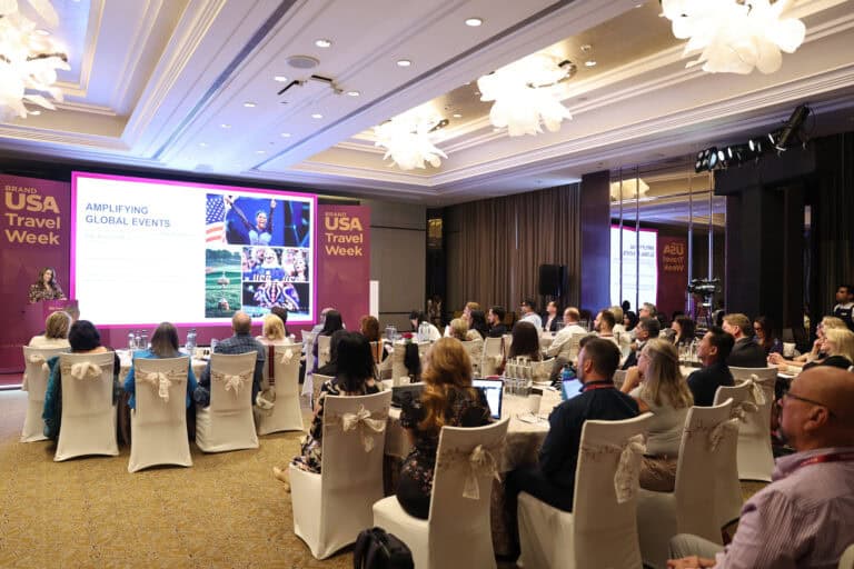 Attendees at the Brand USA Travel Week India 2027 conference in a luxurious hotel ballroom.